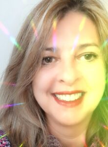 Uma mulher sorrindo, emitindo enrgia para o universo.